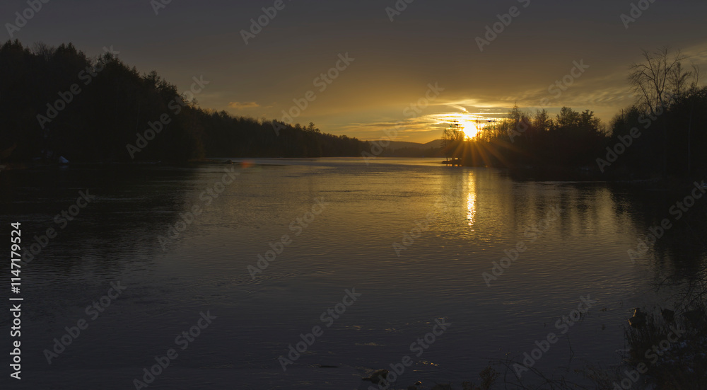 Sunset over a river with some clouds in the sky Sunset over a river with some clouds in the sky