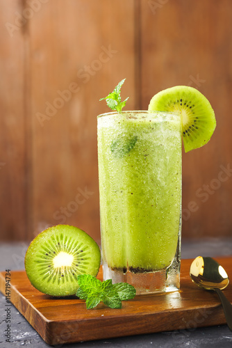 a glass of kiwi fruit juice, on a wooden background