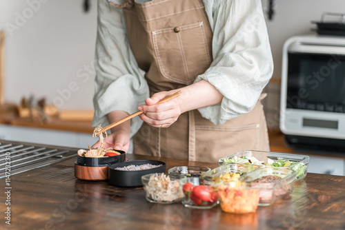 キッチンでお弁当を作る女性の手元
