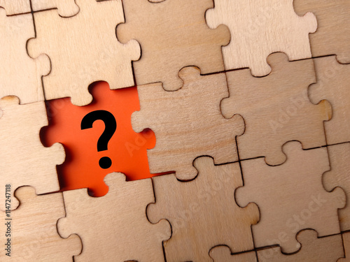 Black question mark placed on last piece of jigsaw puzzle