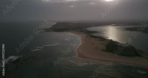 Newcastle Harbour at Nobby's Beach lighthouse during sunset after storm 