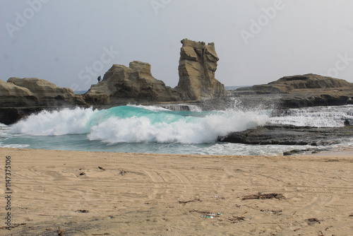 View of the crashing waves washing the beach, with a very beautiful cliff background on Klayar Beach, Pacitan. photo