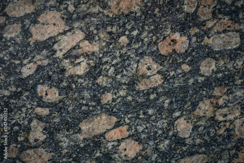 Granite stone showing pink feldspar crystals embedded in dark matrix