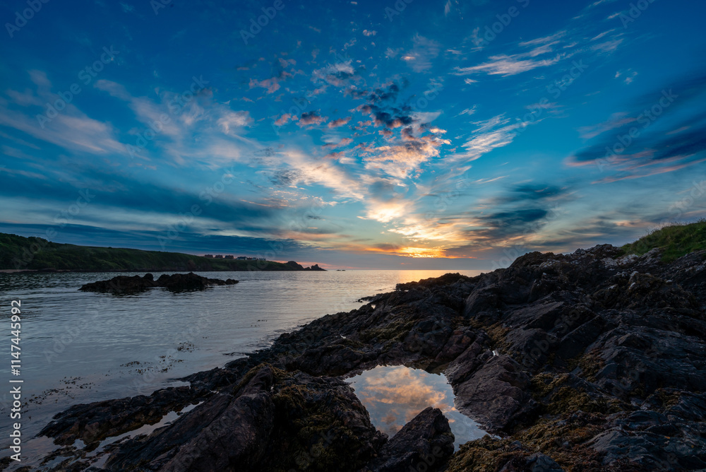 Obraz premium Colourful sunrise at coast reflected in rock pool