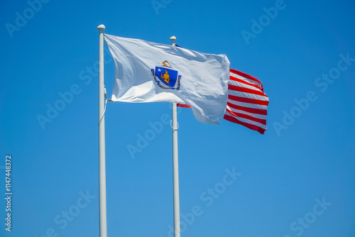 Massachusetts state flag and USA flag waving on the pole in the wind photo