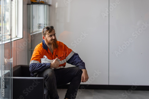 Young adult worker sitting on the couch inside the office. photo