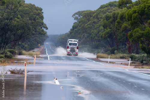 A semi-trailer truck driving through water over a flooded road near Kalgoorlie in Western Australia photo