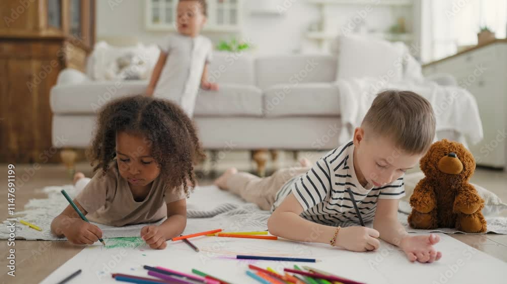 Happy family, mixed race children playing together in room in calm day, drawing. African American girl and Caucasian boy lying on floor, drawing pictures by crayons, happiness and joy, diversity Happy family, mixed race children playing together in room in calm day, drawing. African American girl and Caucasian boy lying on floor, drawing pictures by crayons, happiness and joy, diversity