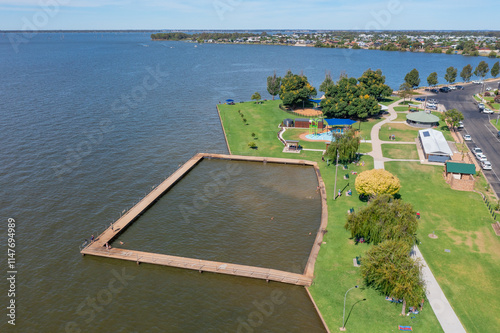 Aerial view of a swimming enclosure and playground on the shore of a town lake photo