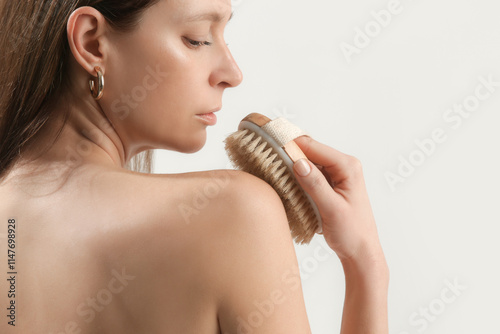 Dry body brush, Woman dry brushing body to reduce cellulite, detoxify the lymphatic system, and achieve beautiful smooth skin. Dry skin brushing as part of morning health and energy routine.	