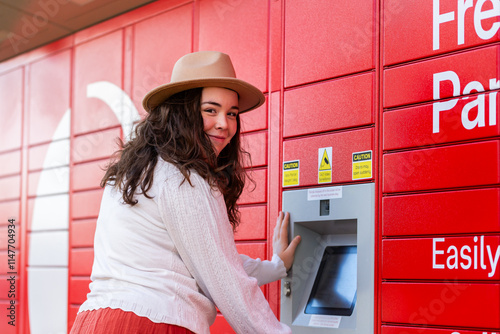 Young lady picking up parcel from post office collection boxes photo