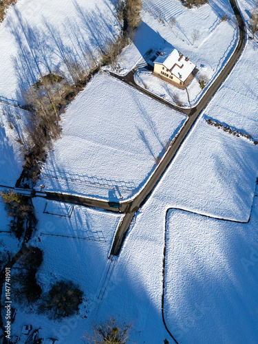 Serene winter landscape in Rocchetta, Morfasso, Italy, features snow and a solitary house photo