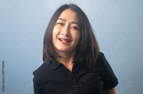 Asian woman wearing shirt black standing isolated blue background smiling shocked face and wow surprise of impressed expression looking at camera photo