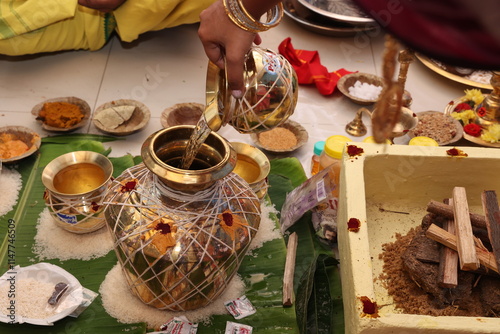 kumbum a decorative pot kept in hindu pooja as a sacred item, pouring holy water into the kumbham photo