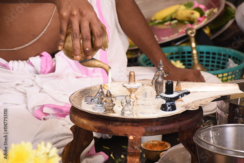 Performing Pooja for Hindu god siva linga with milk, honey and coconut water	

