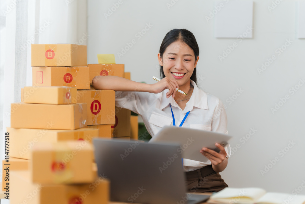 Confidently Growing: A smiling young businesswoman with a confident smile sits at her desk, surrounded by stacked boxes, ready to tackle the day ahead. Confidently Growing: A smiling young businesswoman with a confident smile sits at her desk, surrounded by stacked boxes, ready to tackle the day ahead.