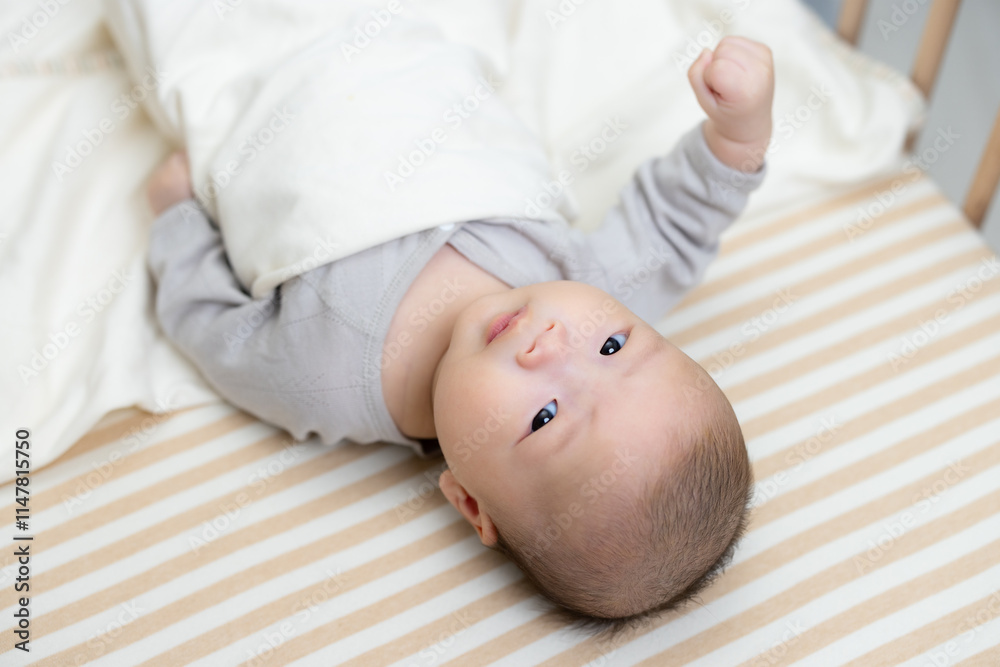 Baby peacefully lying down in baby cot Baby peacefully lying down in baby cot