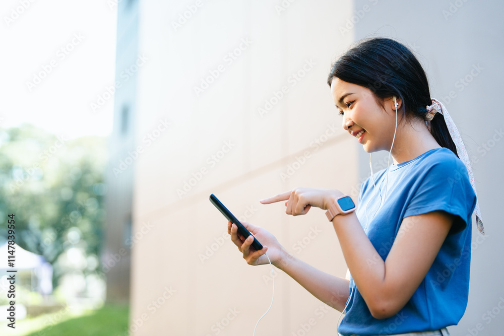 Happy relaxed woman in wireless headphones or earphones choosing, listening favorite music from mobile phone in urban city sunny street. Travel, tourism, technology, blogging concept. Happy relaxed woman in wireless headphones or earphones choosing, listening favorite music from mobile phone in urban city sunny street. Travel, tourism, technology, blogging concept.