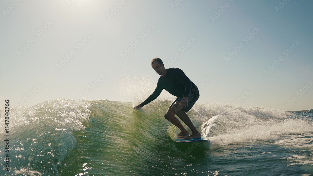 A wakeboarder performs exciting tricks on his board, moving quickly through the water. The footage shows smooth turns, jumps and acrobatics, highlighting the athlete's skill and endurance. Ideal for t A wakeboarder performs exciting tricks on his board, moving quickly through the water. The footage shows smooth turns, jumps and acrobatics, highlighting the athlete's skill and endurance. Ideal for t