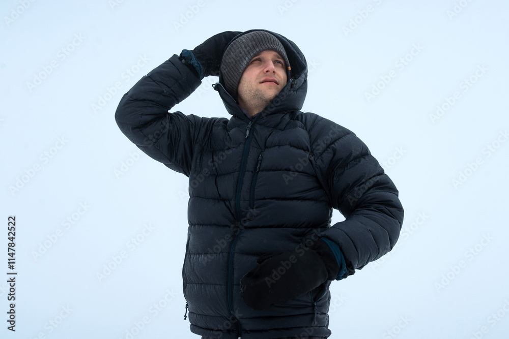 Mountaineer Hiking in Snowstorm with Strong Winds and Low Clouds
