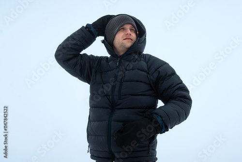 Mountaineer Hiking in Snowstorm with Strong Winds and Low Clouds photo