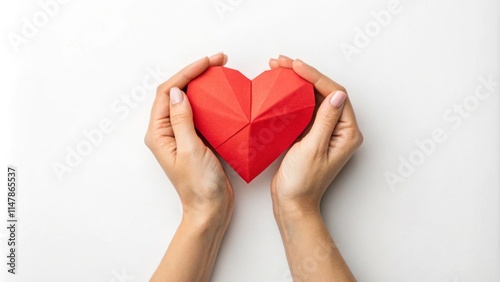 Woman holding red origami heart in her hands, representing love and affection