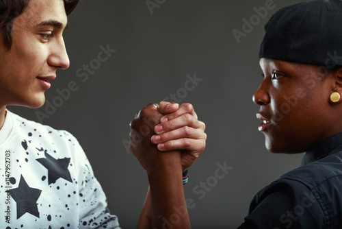 Two teenagers arm wrestling, showing strength and determination
