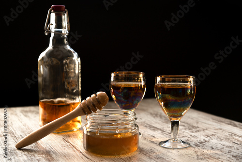 Fotografie Still life close-up of two glasses of honey mead (medovukha) with honey dipper o