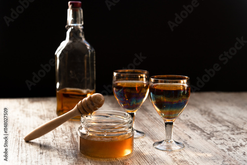 Quadro su tela Still life close-up of two glasses of honey mead (medovukha) with honey dipper o