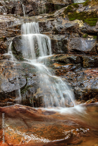 A waterfall is flowing down a rocky cliff