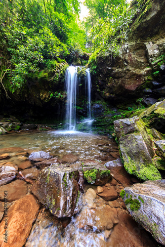 Fototapeta Naklejka Na Ścianę i Meble -  A waterfall is flowing into a small pool of water