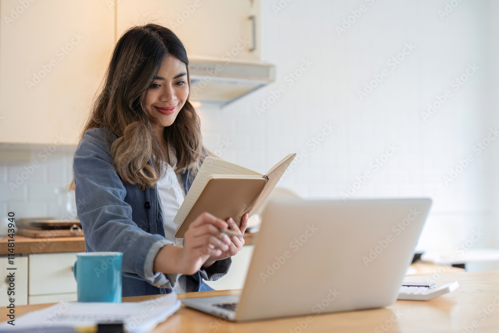Young Woman Freelancer Working from Home with Laptop and Notebook in Modern Kitchen Setting Young Woman Freelancer Working from Home with Laptop and Notebook in Modern Kitchen Setting
