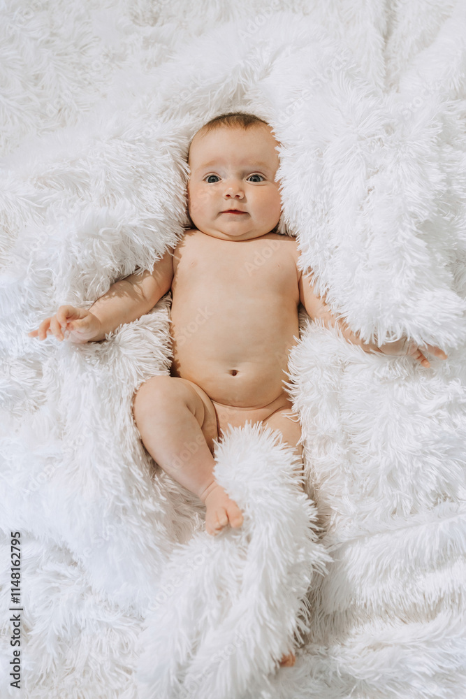 A baby is laying on a white blanket, with its head tilted to the side. The baby is looking at the camera, and its body is covered in white fur. Concept of innocence and curiosity A baby is laying on a white blanket, with its head tilted to the side. The baby is looking at the camera, and its body is covered in white fur. Concept of innocence and curiosity