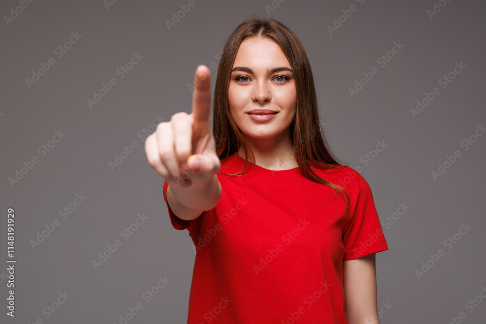 Beautiful young woman hand pressing invisible button on gray background Beautiful young woman hand pressing invisible button on gray background