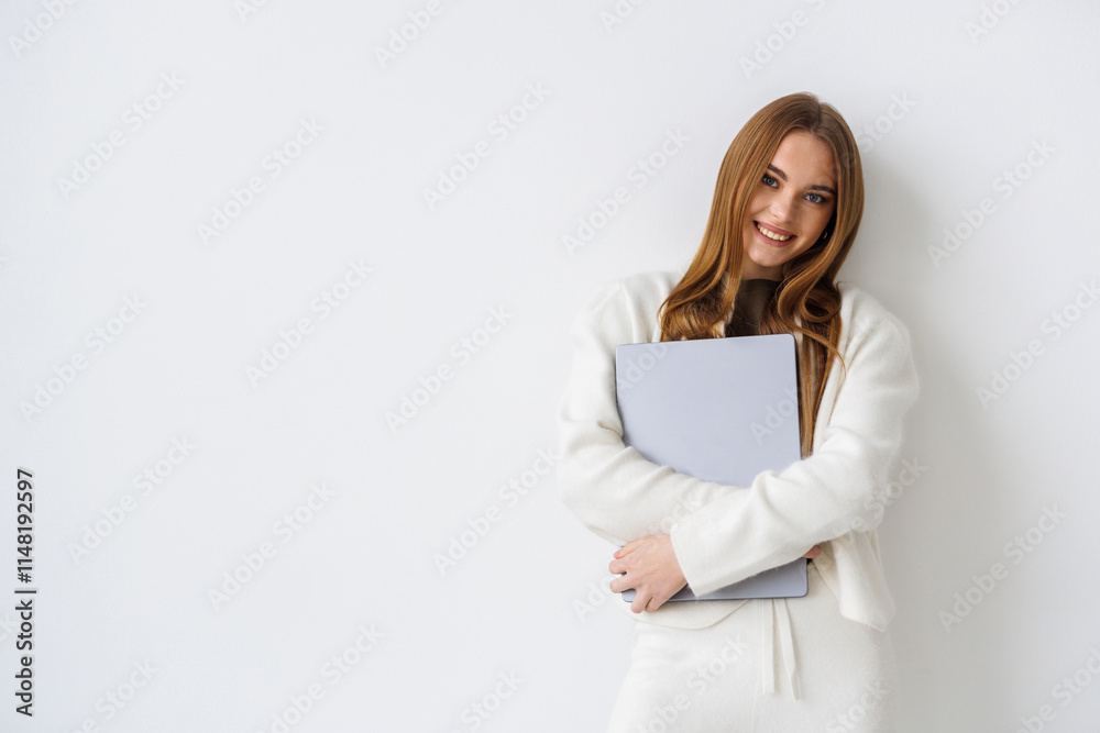 Portrait of a woman standing isolated over white background, holding laptop Portrait of a woman standing isolated over white background, holding laptop