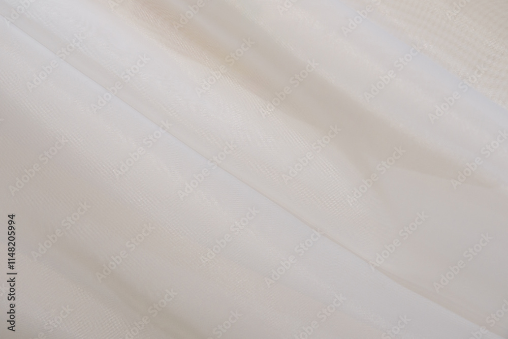 Obraz premium Soft beige fabric gracefully draped on a smooth surface in natural light
