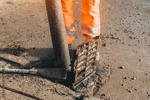 Workers repair drainage system in urban area, ensuring proper water flow on a sunny day