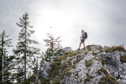 Wide-angle shot male hiker backpack mountain top moody sky exploration solitude photo