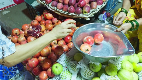 Lady buying pomegranate from market
