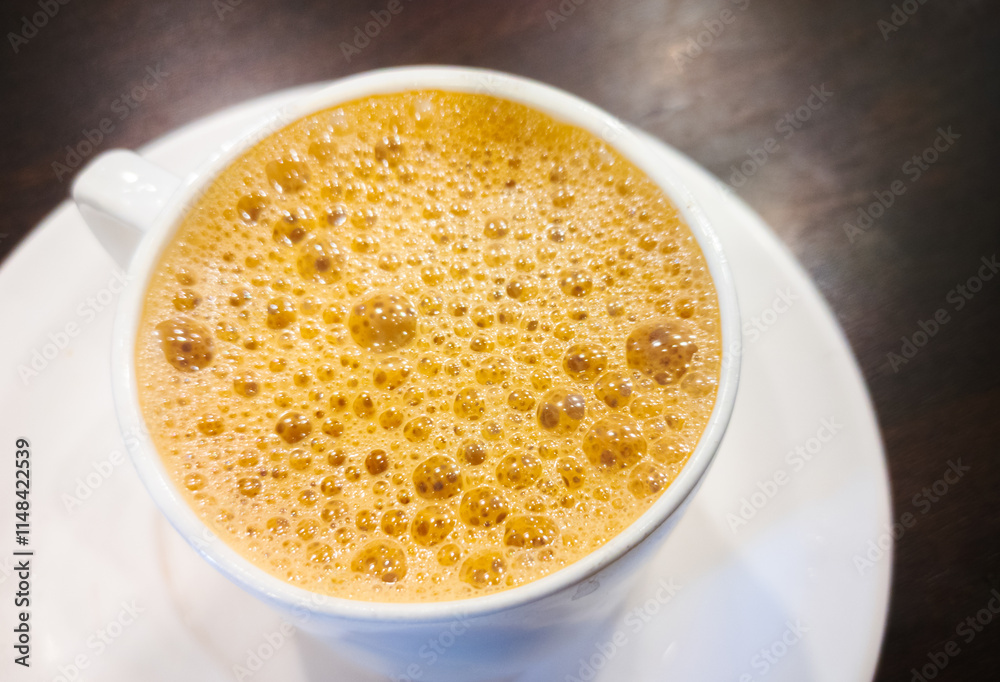 Hot tea in a white cup with a saucer on a wooden table. Hot tea in a white cup with a saucer on a wooden table.