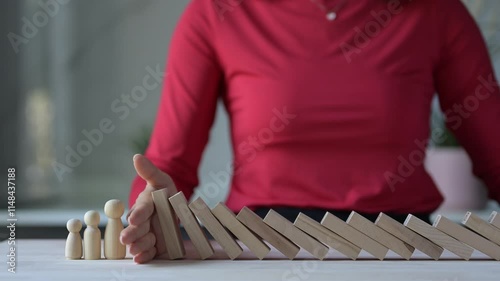 Managing Business Risks During a Crisis Hand Stopping Dominoes to Prevent Falling Risks in the Workplace Environment