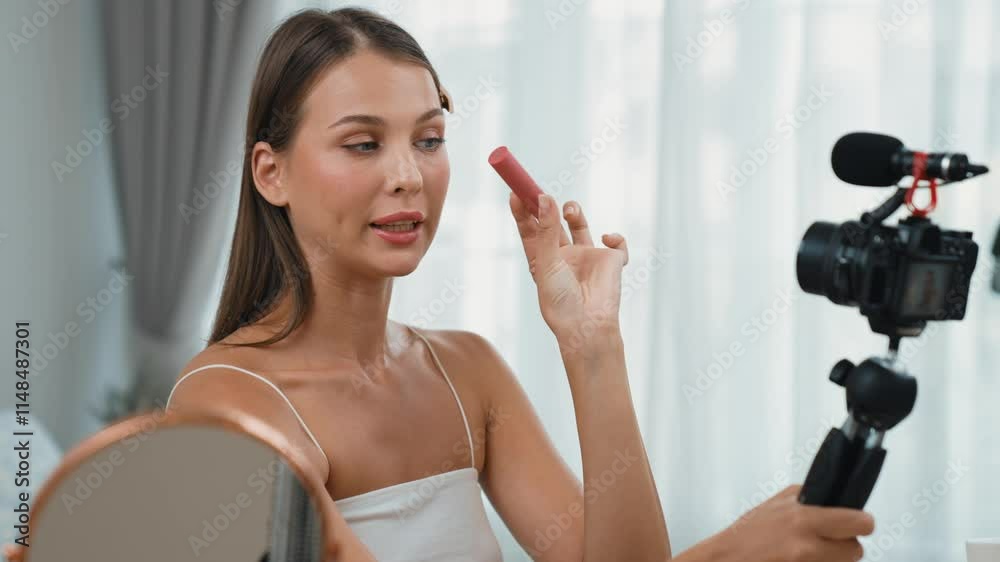 Young woman making beauty and cosmetic tutorial video content for social media. Beauty blogger smiles to camera while showing how to beauty care to audience or followers. Adit Young woman making beauty and cosmetic tutorial video content for social media. Beauty blogger smiles to camera while showing how to beauty care to audience or followers. Adit
