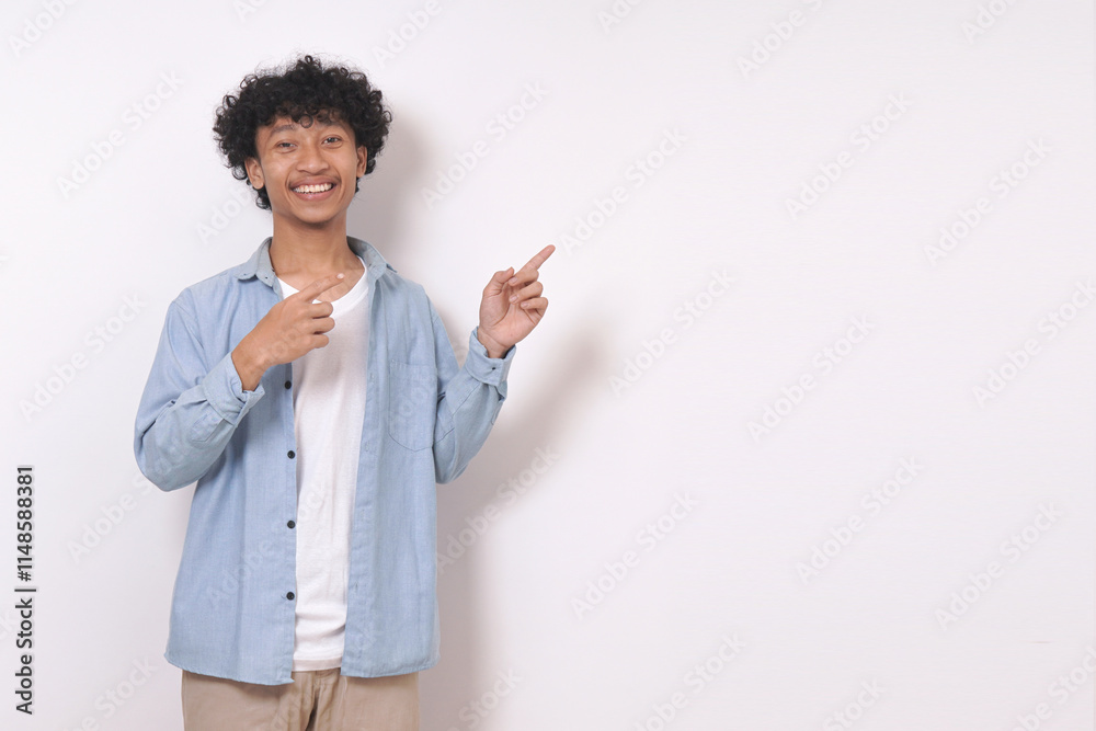 young man standing and pointing to side with smile isolated on white background. young man standing and pointing to side with smile isolated on white background.