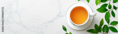 A serene cup of tea surrounded by fresh green leaves on a marble surface. photo