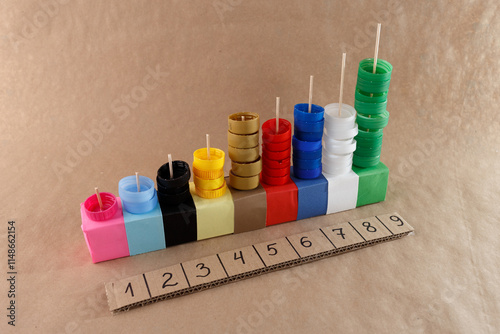 a colorful arrangement of plastic bottle caps, numbers 1 to 9, counting or sorting activity, for educational purposes, using everyday objects like bottle caps and colored blocks. photo