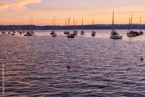 Sunset over Lake with Pier and Sailboats, Serene Waterfront Scene, Orange and Pink Sky, Calm Water, Silhouettes of Boats, Tranquil Evening, Reflections on Water, Peaceful Marina, Dusk Landscape