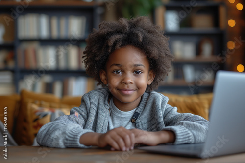 Child enjoys learning at home while sitting at a table with laptop in cozy indoor environment