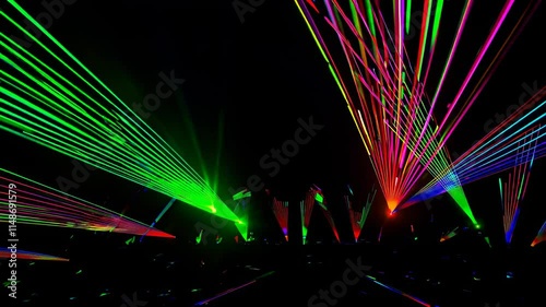 Vibrant laser show with colorful lights illuminating the night sky at a music festival