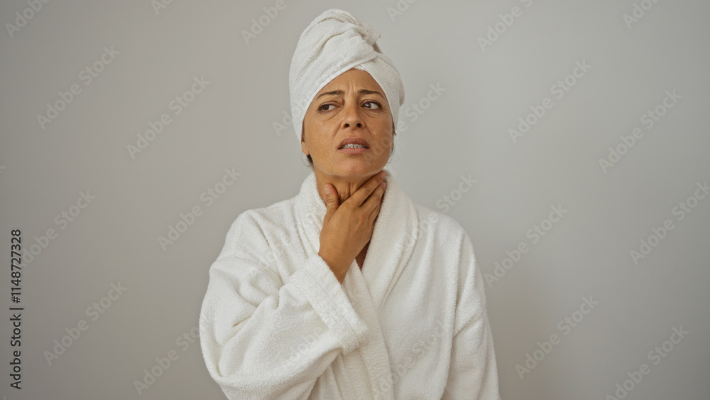 Woman wearing bathrobe holds her throat with a concerned expression isolated on a white background Woman wearing bathrobe holds her throat with a concerned expression isolated on a white background