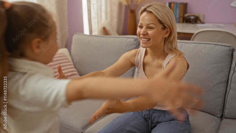 Woman smiling while embracing daughter in cozy living room, showcasing a tender family moment in a comfortable home setting. Woman smiling while embracing daughter in cozy living room, showcasing a tender family moment in a comfortable home setting.